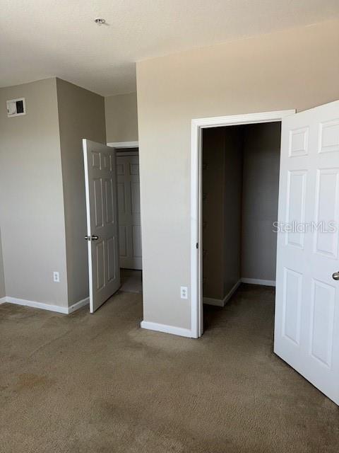 unfurnished bedroom with a closet and carpet floors