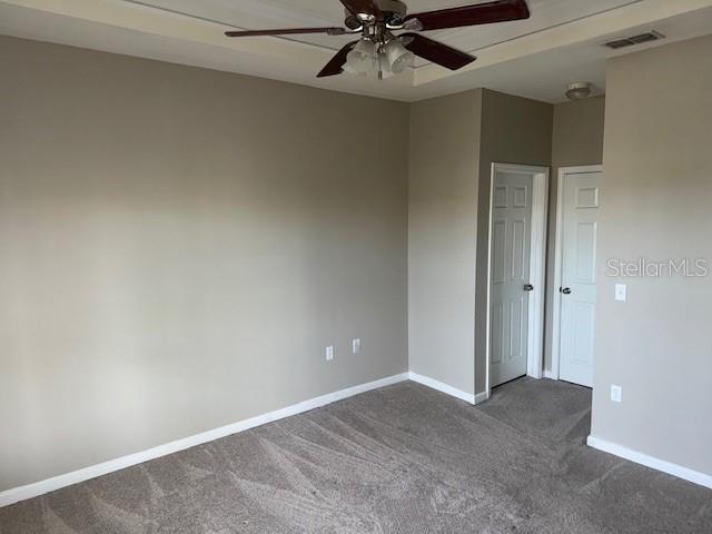 carpeted spare room featuring ceiling fan