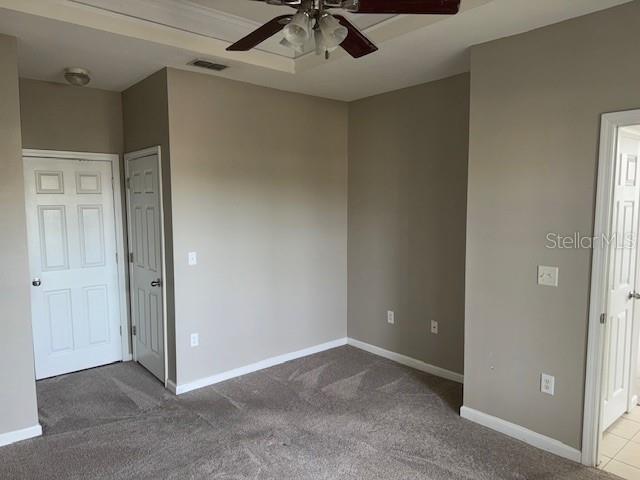 carpeted spare room featuring ceiling fan