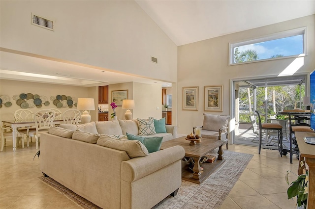 living room featuring light tile patterned floors and high vaulted ceiling