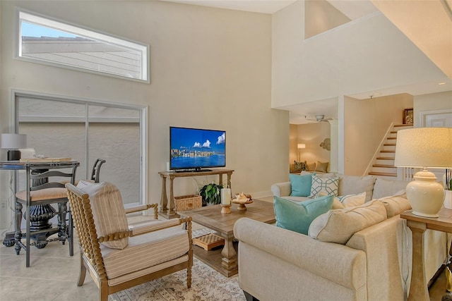 living room with a towering ceiling and a fireplace