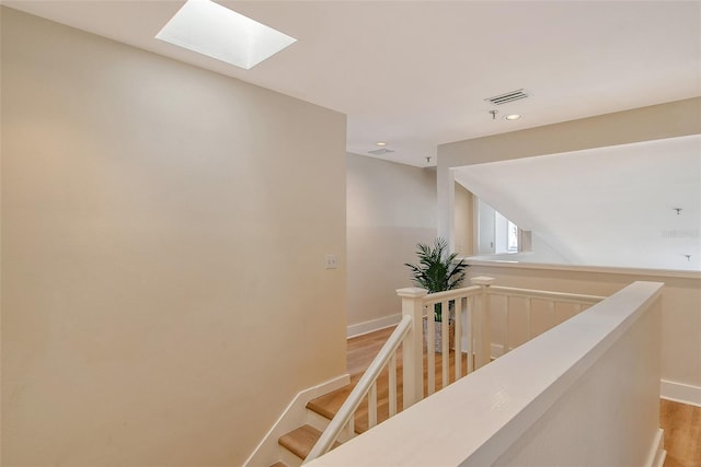 staircase featuring hardwood / wood-style floors and a skylight