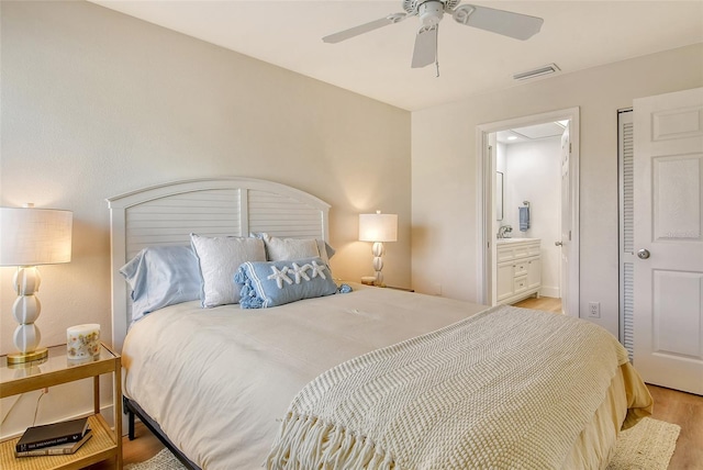 bedroom with sink, ensuite bath, light hardwood / wood-style flooring, and ceiling fan