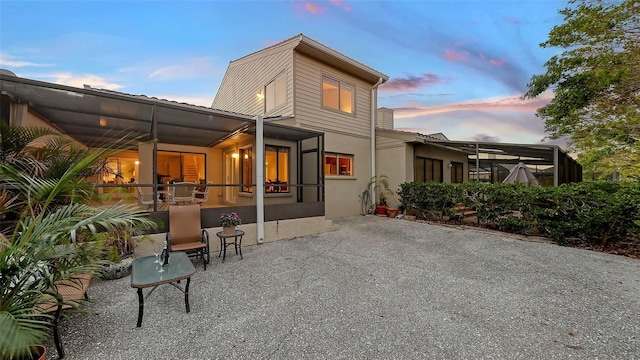 back house at dusk featuring a patio