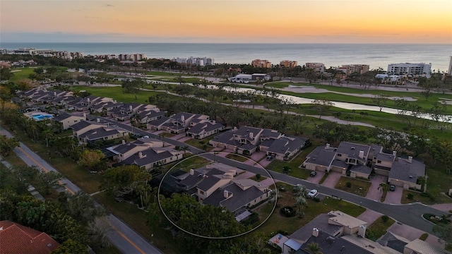 aerial view at dusk featuring a water view