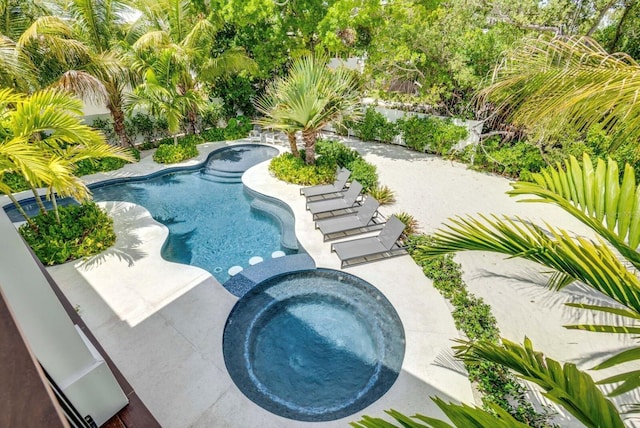 view of swimming pool featuring a patio area and an in ground hot tub