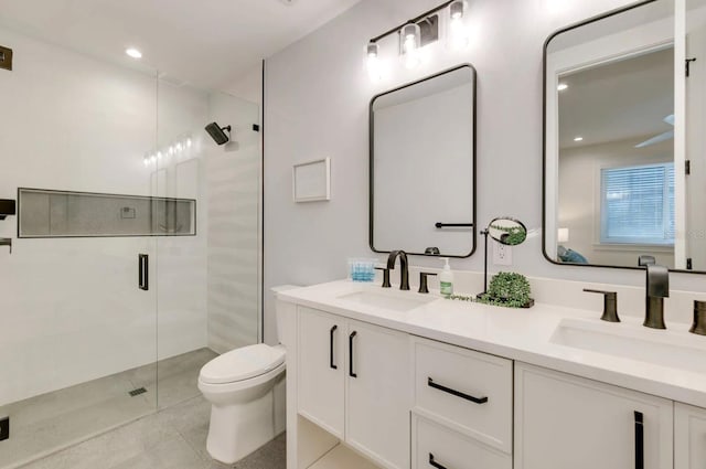 bathroom with vanity, toilet, and a shower with door