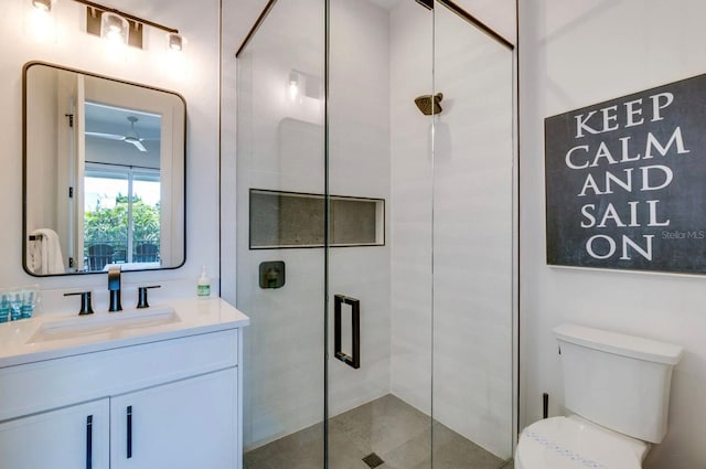 bathroom with a shower with door, vanity, and toilet