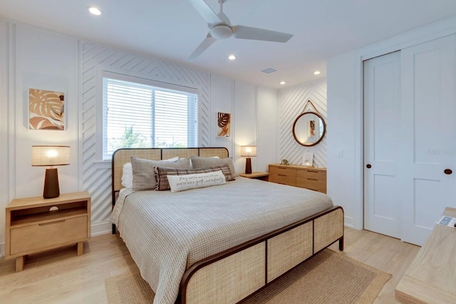 bedroom with ceiling fan, a closet, and light hardwood / wood-style flooring