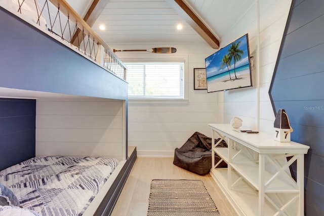 bedroom featuring vaulted ceiling with beams and light wood-type flooring