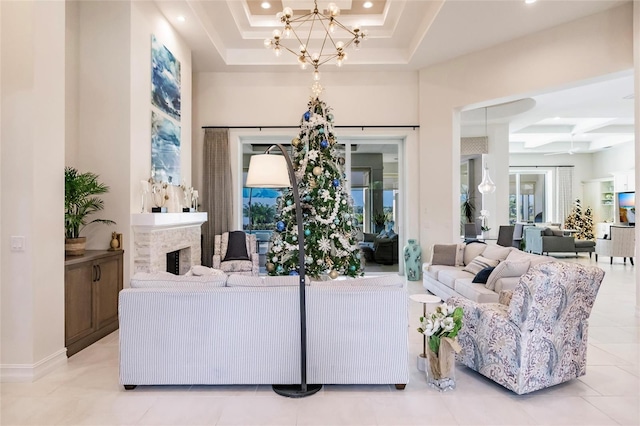 tiled living room featuring a raised ceiling, coffered ceiling, and a notable chandelier