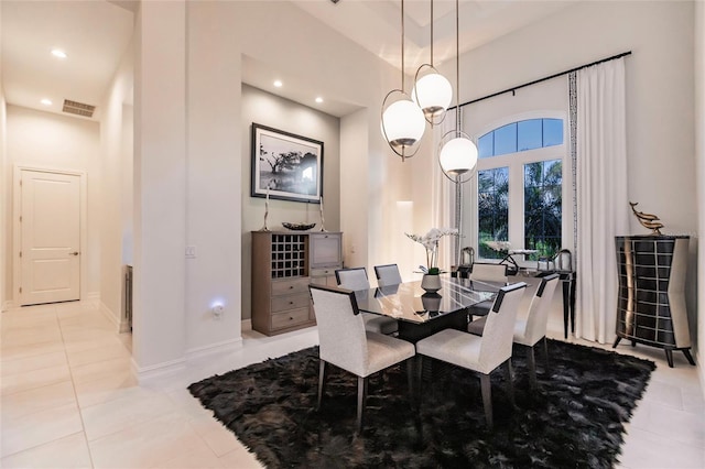 dining room with light tile patterned flooring and a high ceiling