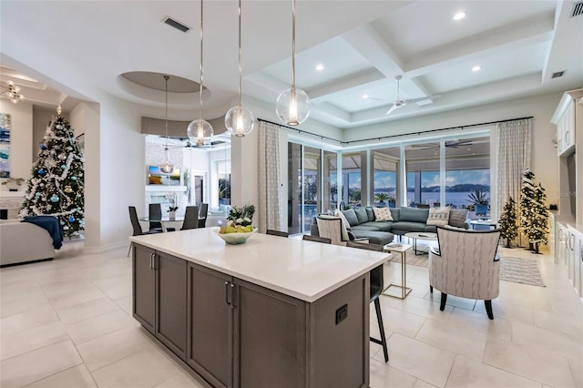 kitchen featuring ceiling fan, coffered ceiling, pendant lighting, a tray ceiling, and white cabinets