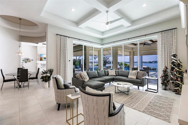 tiled living room featuring a water view, a raised ceiling, ceiling fan, and coffered ceiling