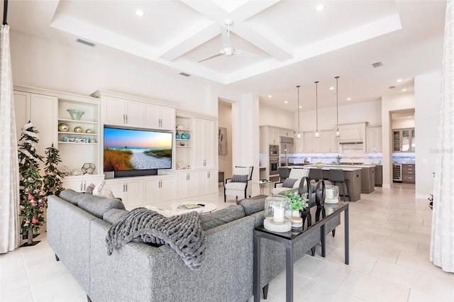 tiled living room with ceiling fan and coffered ceiling