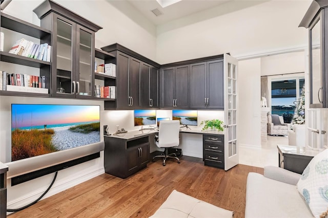 office space featuring built in desk and hardwood / wood-style flooring