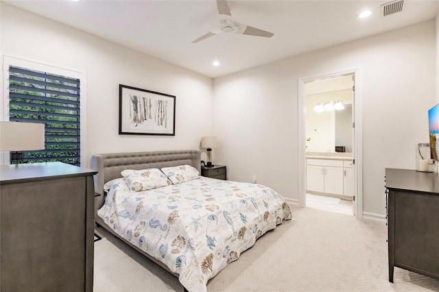 bedroom featuring connected bathroom, light colored carpet, and ceiling fan