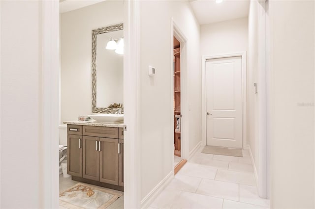 hallway with sink and light tile patterned flooring