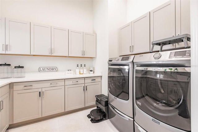 clothes washing area featuring cabinets, independent washer and dryer, and light tile patterned floors