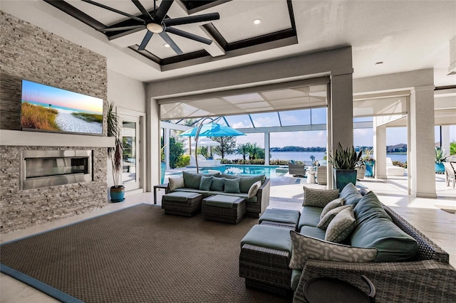 living room featuring a water view, plenty of natural light, coffered ceiling, and ceiling fan