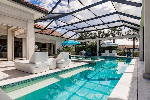 view of pool featuring an in ground hot tub, a patio, exterior fireplace, and a lanai