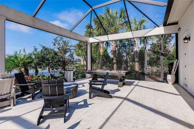 view of patio / terrace featuring glass enclosure and an outdoor fire pit