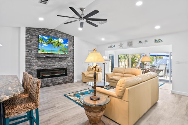 living room with ceiling fan, lofted ceiling, a fireplace, and light hardwood / wood-style flooring