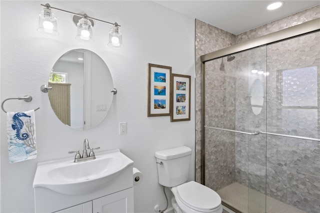 bathroom with vanity, toilet, and an enclosed shower