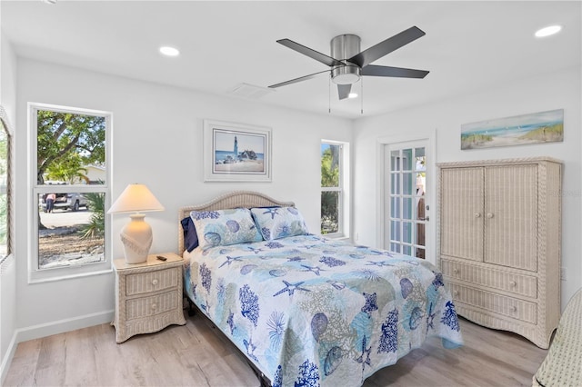 bedroom with ceiling fan, wood-type flooring, and multiple windows