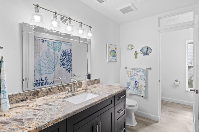 bathroom featuring vanity, hardwood / wood-style flooring, and toilet