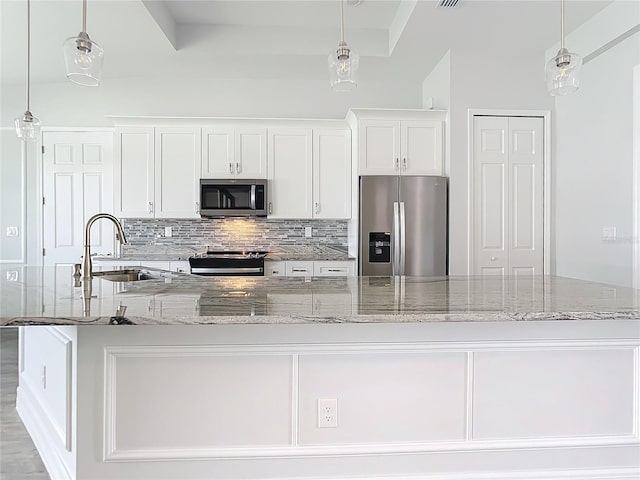 kitchen with pendant lighting, a large island, white cabinetry, and stainless steel appliances