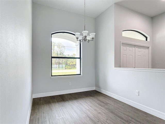 unfurnished room featuring dark hardwood / wood-style floors and a chandelier