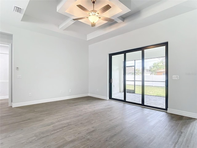 spare room featuring hardwood / wood-style floors, ceiling fan, and beam ceiling