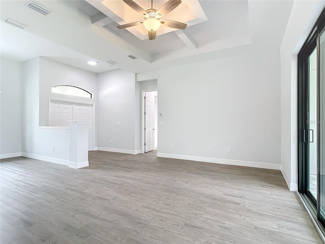 unfurnished living room with light wood-type flooring, a raised ceiling, and ceiling fan