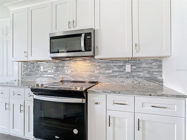 kitchen with tasteful backsplash, white cabinetry, light stone countertops, and black range with electric cooktop