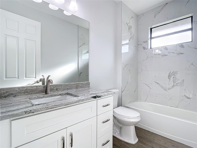 full bathroom with vanity, hardwood / wood-style flooring, toilet, and tiled shower / bath combo