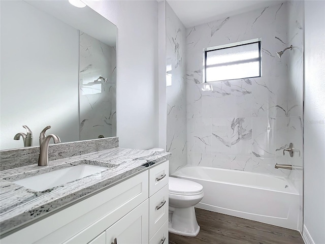 full bathroom with hardwood / wood-style flooring, tiled shower / bath combo, toilet, and vanity