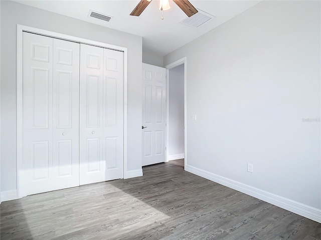 unfurnished bedroom featuring ceiling fan, wood-type flooring, and a closet