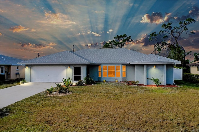 view of front of home with a yard and a garage