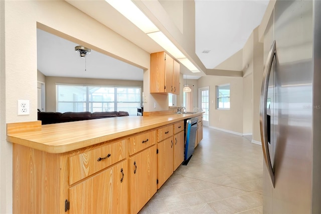 kitchen with kitchen peninsula, appliances with stainless steel finishes, butcher block countertops, and hanging light fixtures