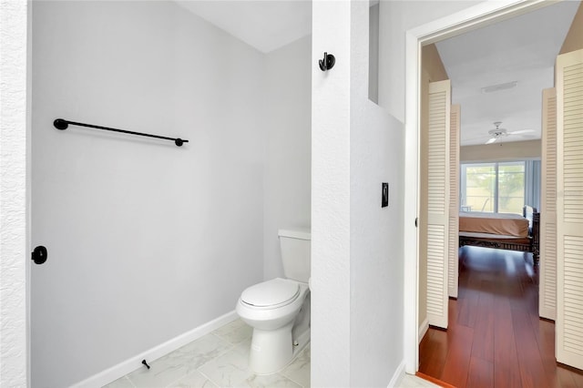 bathroom with ceiling fan and toilet