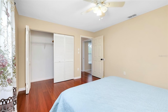 bedroom with ceiling fan, dark hardwood / wood-style floors, and a closet