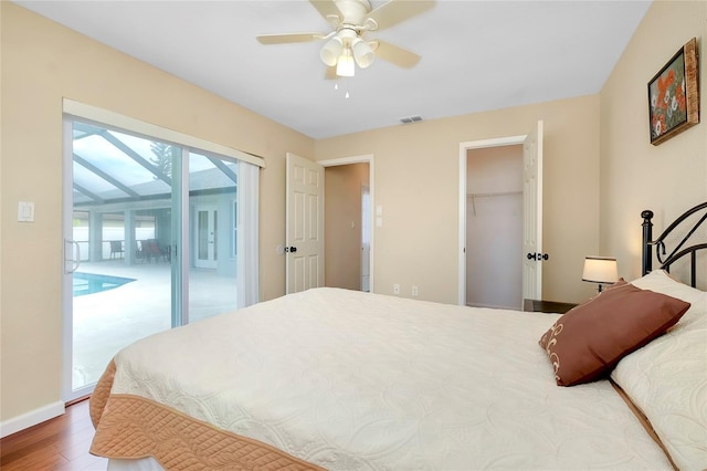 bedroom featuring a walk in closet, access to outside, ceiling fan, hardwood / wood-style floors, and a closet