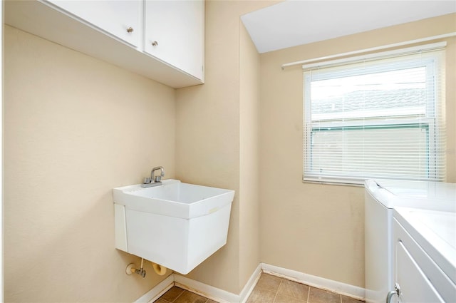 laundry room with washer and dryer, cabinets, and sink