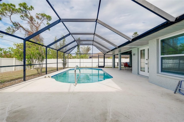 view of swimming pool featuring glass enclosure, french doors, and a patio