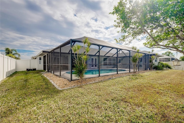 view of swimming pool with a lanai and a lawn