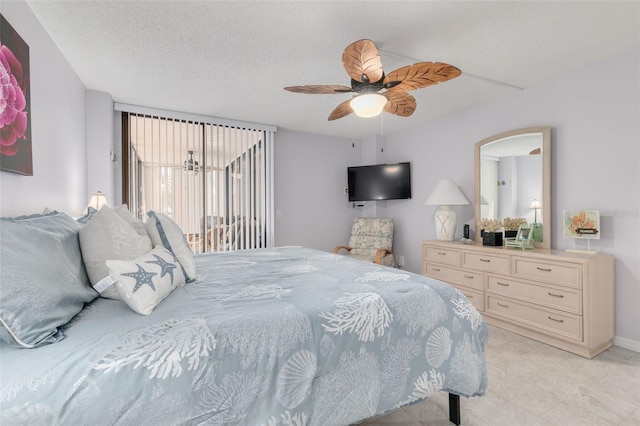 bedroom with ceiling fan, access to exterior, and a textured ceiling