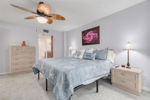 bedroom featuring a textured ceiling, connected bathroom, and ceiling fan