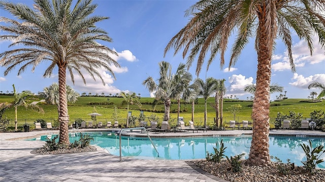 view of pool featuring a rural view and a patio area