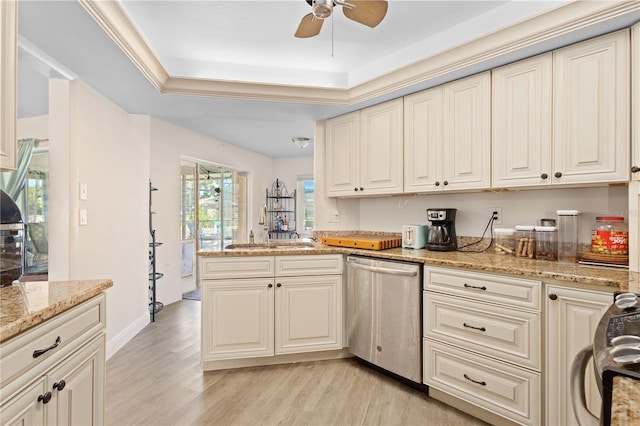 kitchen with light stone counters, light hardwood / wood-style flooring, stainless steel dishwasher, crown molding, and a tray ceiling